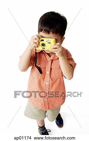 Picture - Boy standing and looking through camera. Fotosearch