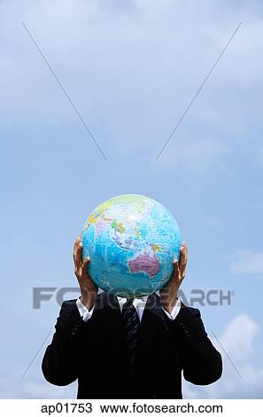Businessman holding globe in front of his face View Large Photo Image Stock Image - Businessman holding globe in front of his face. Fotosearch