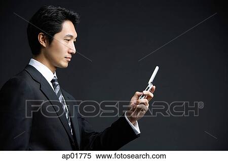 Businessman holding mobile phone View Large Photo Image Stock Photography - Businessman holding mobile phone. Fotosearch