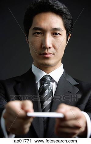 Businessman holding out business card View Large Photo Image Stock Image - Businessman holding out business card. Fotosearch