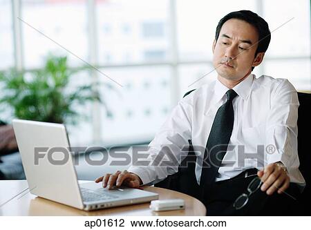 Businessman in office using laptop View Large Photo Image Stock Image - Businessman in office using laptop. Fotosearch