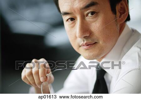 Stock Image - Businessman looking at camera, head shot. Fotosearch
