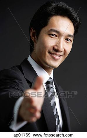 Businessman, looking at camera, offering hand View Large Photo Image Stock Photo - Businessman, looking at camera, offering hand. Fotosearch