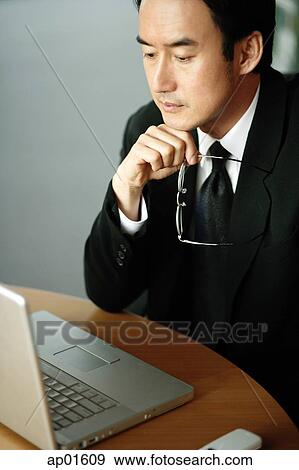 Stock Photo - Businessman looking at laptop, high angle view. Fotosearch