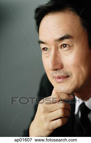 Businessman looking away, hand on chin, portrait View Large Photo Image Stock Photo - Businessman looking away, hand on chin, portrait. Fotosearch