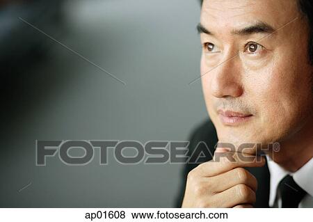 Businessman looking away, hand on chin View Large Photo Image Stock Photo - Businessman looking away, hand on chin. Fotosearch