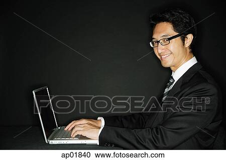 Businessman wearing glasses, with laptop, smiling at camera View Large Photo Image Stock Image - Businessman wearing glasses, with laptop, smiling at camera. Fotosearch