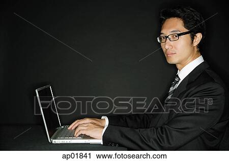 Businessman wearing glasses, with laptop, portrait View Large Photo Image Stock Image - Businessman wearing glasses, with laptop, portrait. Fotosearch