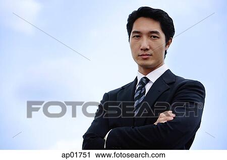 Businessman with arms crossed, looking at camera View Large Photo Image Stock Image - Businessman with arms crossed, looking at camera. Fotosearch