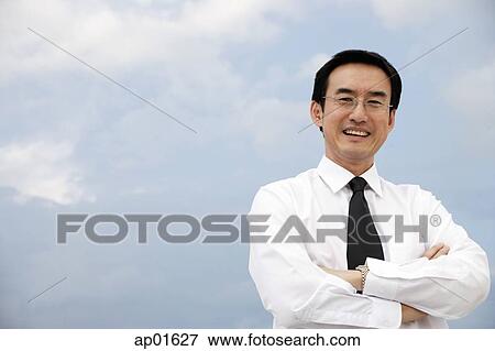 Businessman with arms crossed, smiling View Large Photo Image Stock Photo - Businessman with arms crossed, smiling. Fotosearch