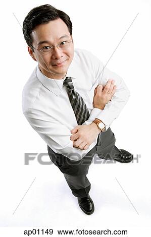 Businessman with arms crossed, standing, looking at camera View Large Photo Image Stock Photo - Businessman with arms crossed, standing, looking at camera. Fotosearch