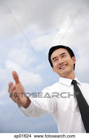 Businessman with hand outstretched, smiling View Large Photo Image Picture - Businessman with hand outstretched, smiling. Fotosearch