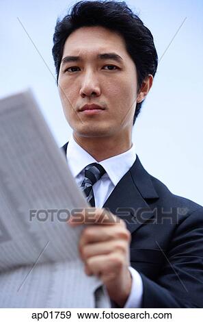 Businessman with newspaper, looking at camera View Large Photo Image Stock Photo - Businessman with newspaper, looking at camera. Fotosearch