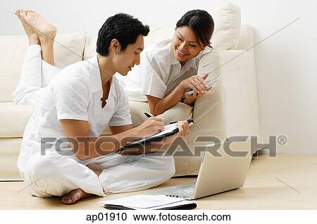 Couple at home in living room, doing home finances View Large Photo Image Stock Image - Couple at home in living room, doing home finances. Fotosearch