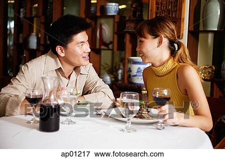 Couple dining in restaurant, sitting face to face View Large Photo Image Stock Photo - Couple dining in restaurant, sitting face to face. Fotosearch