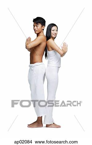 Couple doing yoga, standing back to back, looking at camera View Large Photo Image Picture - Couple doing yoga, standing back to back, looking at camera. Fotosearch