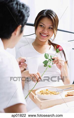 Stock Image - Couple having breakfast in bed. Fotosearch