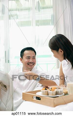 Couple in bedroom, breakfast tray on bed View Large Photo Image Stock Photography - Couple in bedroom, breakfast tray on bed. Fotosearch