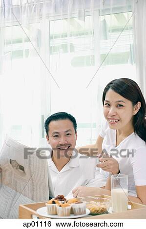 Couple in bedroom, breakfast tray on bed, looking at camera View Large Photo Image Stock Photograph - Couple in bedroom, breakfast tray on bed, looking at camera. Fotosearch