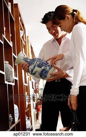 Couple looking at Chinese vase in antique shop View Large Photo Image Stock Image - Couple looking at Chinese vase in antique shop. Fotosearch