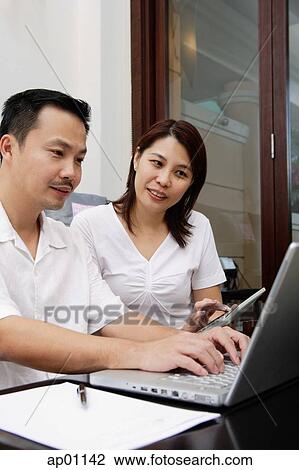 Couple looking at laptop View Large Photo Image Stock Image - Couple looking at laptop. Fotosearch
