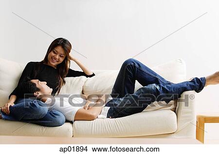Picture - Couple on sofa, man lying on womans lap. Fotosearch