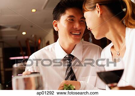 Stock Image - Couple sitting, looking at each other. Fotosearch