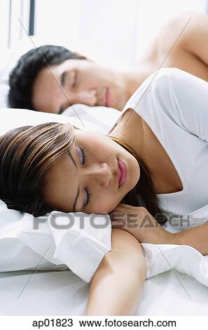 Couple sleeping on bed View Large Photo Image Stock Image - Couple sleeping on bed. Fotosearch