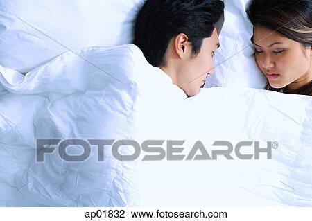 Stock Image - Couple sleeping on bed. Fotosearch