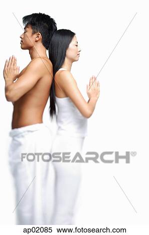 Couple standing back to back doing yoga View Large Photo Image Stock Photography - Couple standing back to back doing yoga. Fotosearch