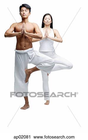 Couple standing in yoga position, tree pose View Large Photo Image Stock Image - Couple standing in yoga position, tree pose. Fotosearch
