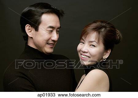 Couple together, woman smiling at camera, man watching her View Large Photo Image Stock Image - Couple together, woman smiling at camera, man watching her. Fotosearch