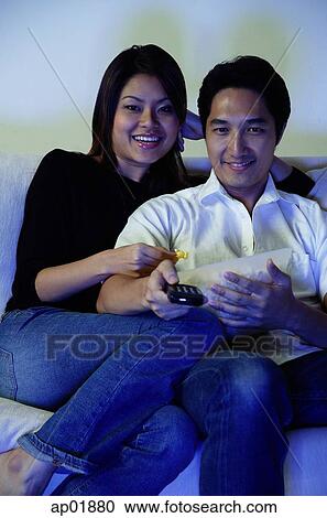 Couple watching TV, eating popcorn View Large Photo Image Stock Image - Couple watching TV, eating popcorn. Fotosearch