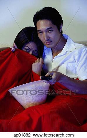 Couple watching TV, woman hiding under blanket View Large Photo Image Stock Image - Couple watching TV, woman hiding under blanket. Fotosearch