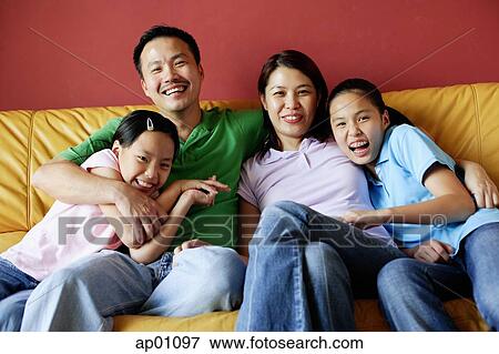 Family of four sitting on sofa, family portrait View Large Photo Image Stock Photo - Family of four sitting on sofa, family portrait. Fotosearch