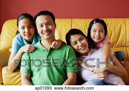 Stock Image - Family of four smiling at camera, portrait. Fotosearch
