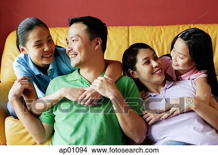 Picture - Family of four smiling at each other. Fotosearch