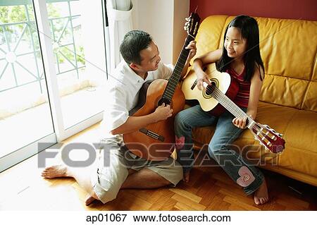 Download Father and daughter with guitars in living room Stock ...