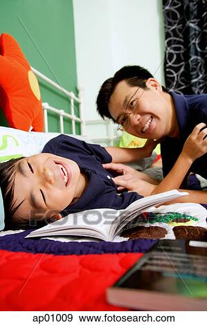 Father tickling son on bed View Large Photo Image Stock Photo - Father tickling son on bed. Fotosearch