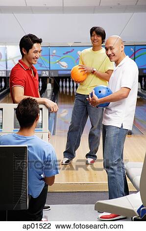 Stock Image - Four men in bowling alley. Fotosearch
