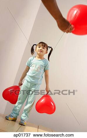 Girl holding balloon, looking at someone standing in front of her View Large Photo Image Stock Photo - Girl holding balloon, looking at someone standing in front of her. Fotosearch