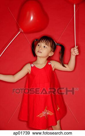 Girl holding heart shaped balloon View Large Photo Image Stock Photo - Girl holding heart shaped balloon. Fotosearch