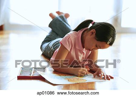 Girl lying on floor, drawing on paper with crayons View Large Photo Image Stock Photograph - Girl lying on floor, drawing on paper with crayons. Fotosearch