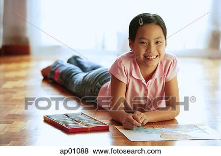 Girl lying on floor, with paper and crayons, looking at camera, smiling View Large Photo Image Stock Photo - Girl lying on floor, with paper and crayons, looking at camera, smiling. Fotosearch