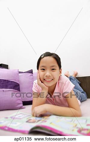 Girl lying on front, looking at camera View Large Photo Image Stock Photography - Girl lying on front, looking at camera. Fotosearch