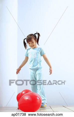 Girl standing, looking at balloons on the floor View Large Photo Image Stock Photo - Girl standing, looking at balloons on the floor. Fotosearch