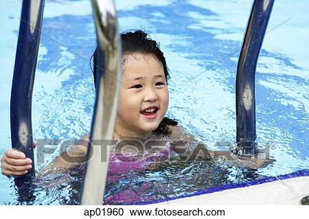 Girl swimming in pool, climbing ladder View Large Photo Image Stock Image - Girl swimming in pool, climbing ladder. Fotosearch