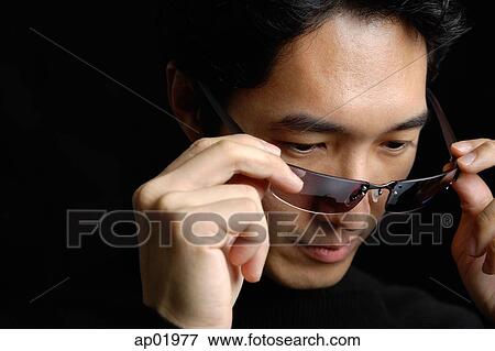 Man adjusting sunglasses View Large Photo Image Stock Photo - Man adjusting sunglasses. Fotosearch