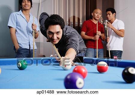 Man aiming pool cue at ball, other men watching in the background View Large Photo Image Stock Photo - Man aiming pool cue at ball, other men watching in the background. Fotosearch