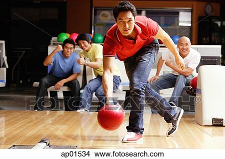 Man bowling, friends cheering in the background View Large Photo Image Picture - Man bowling, friends cheering in the background. Fotosearch